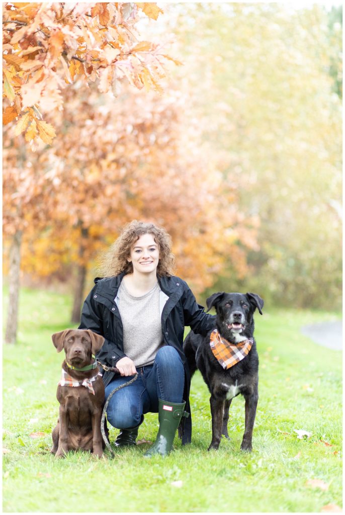woman and her two labradors sitting in grass