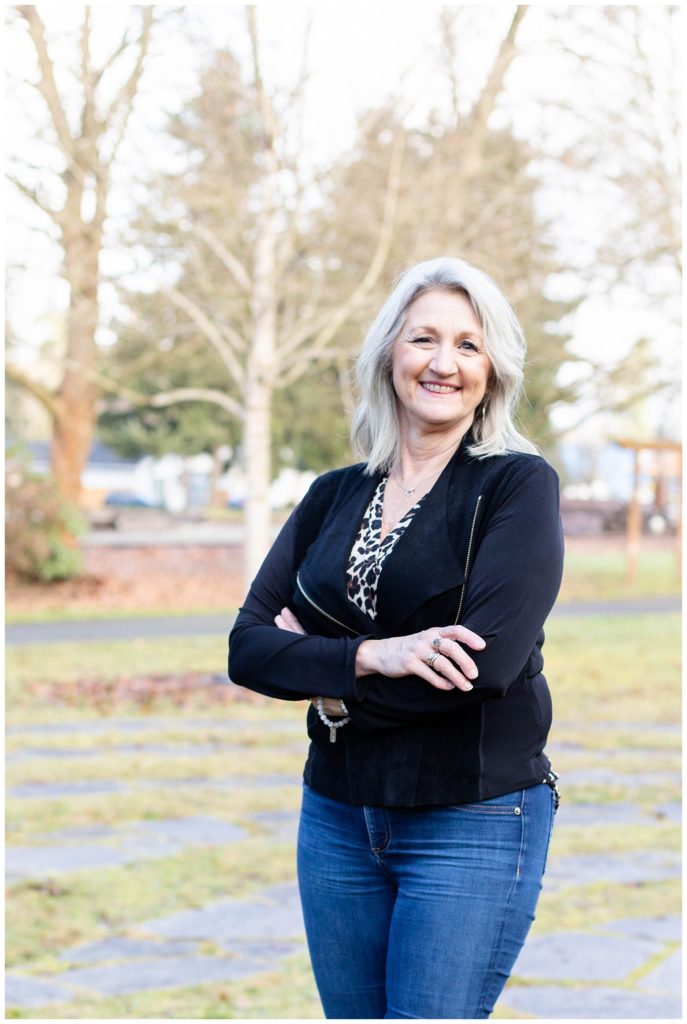 realtor crossing her arms and smiling for headshots outside in a park