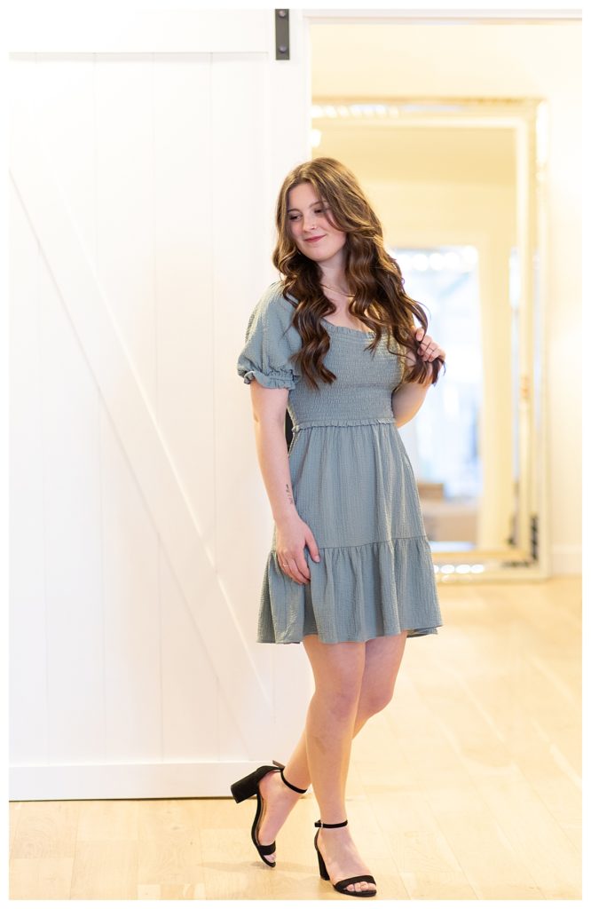 Girl wearing green dress in boutique clothing store and looking off to her side