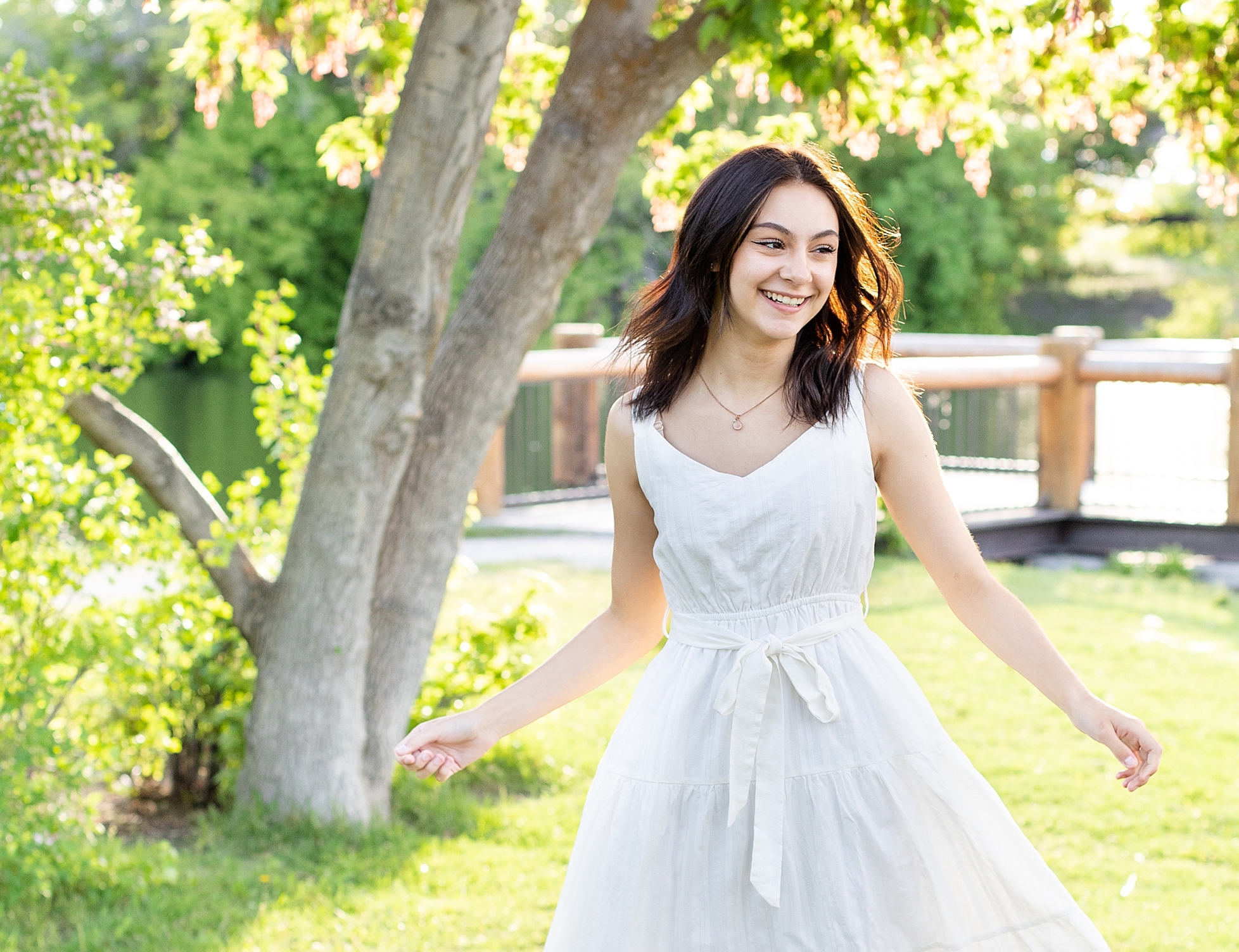 girl twirling in white dress for senior pictures
