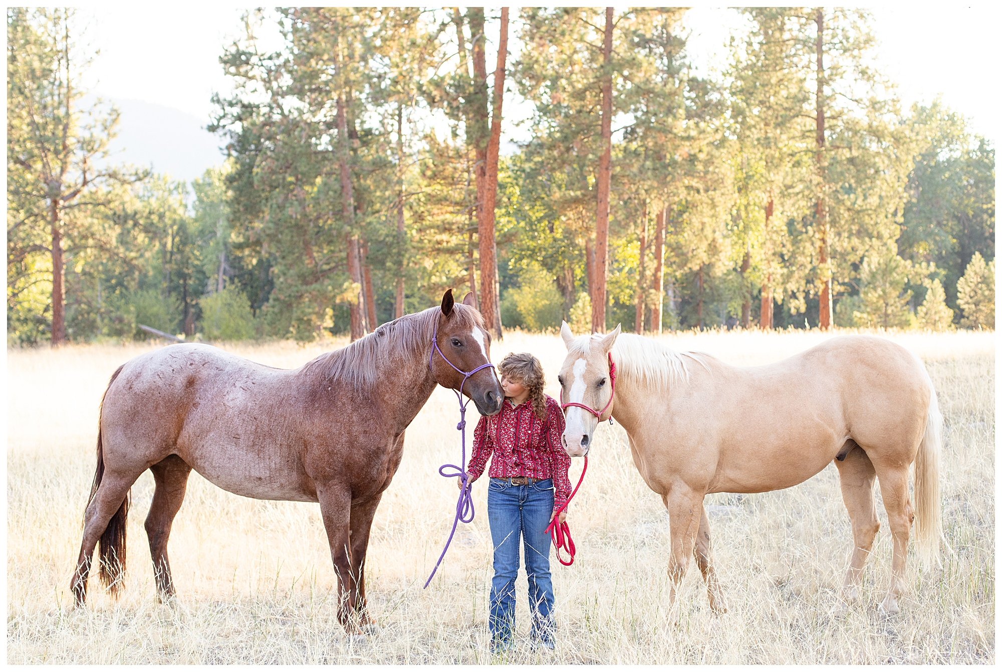 Missoula high school senior girls stands in field with her roan and palamino horse at Council Grove State Park