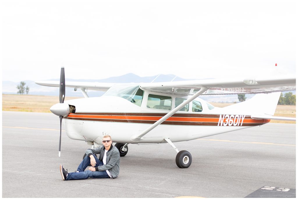 Senior pictures guys ideas with senior sitting in front of plane 