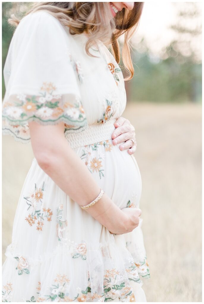 Missoula maternity photos of mom holding in stomach smiling