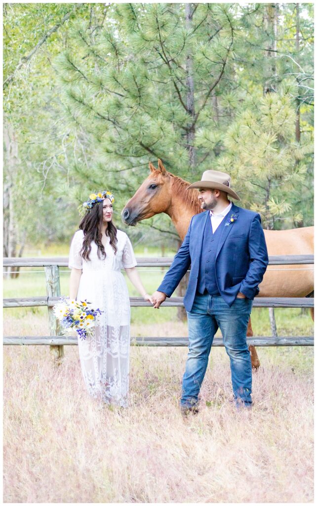 Couple poses in front of horse for Montana luxury ranch elopement 