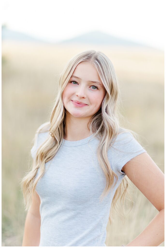 Missoula senior photos with Hellgate High School senior at park standing in field smiling