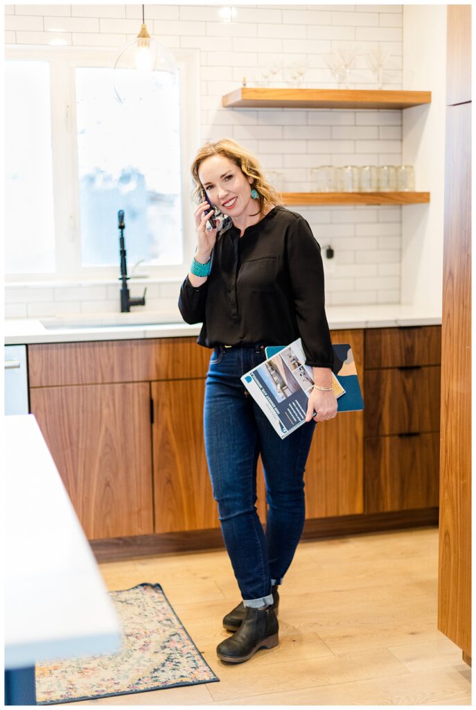 Missoula realtor branding photoshoot in kitchen with realtor talking on phone and holding brochures